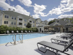 Beautiful swimming pool area at Hawthorne Commons apartments in historic Salem, Massachusetts, surrounded by lush greenery.