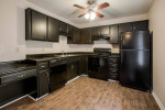 Modern kitchen featuring black appliances and cabinetry in Park Place Apartments, Louisville.