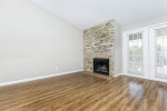 Bright living room featuring a stone fireplace and large windows in Pasadena corporate housing apartment