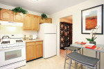Modern kitchen featuring stainless steel appliances and elegant dining setup in a renovated apartment