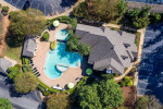 Aerial view of the Amenity Court and swimming pool at Carrington Park apartments with green surroundings.
