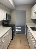 Modern kitchen with white cabinets and stainless steel appliances in an apartment at Bella Terraza, Jacksonville.