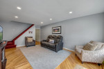 Bright living room with hardwood floors and comfortable seating in Brooklyn home for sale.