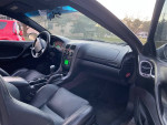Interior view of a 2004 Supercharged GTO featuring leather seats and modern dashboard with green display.