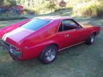 1968 AMC AMX classic muscle car, restored with a red exterior and powerful 401 engine, showcasing vintage style and performance.