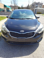 Front view of a black Kia Forte with low mileage and good condition, parked in a lot.