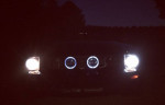 Front view of a 2006 Ford Mustang GT with illuminated headlights at night