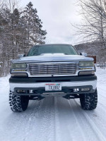 Front view of a Chevy Silverado truck on a snowy road, showcasing its modified design and performance features.