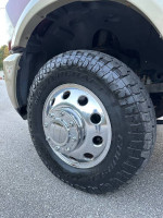 Close-up of a Ram 3500 wheel with new tire and shiny chrome rim on a truck