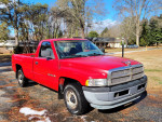 1998 Dodge Ram 1500 V6 in red parked on a driveway, showcasing its clean exterior and newer headlights.