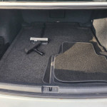 Trunk of 2017 Volkswagen Passat SEL showing clean floor mats and vacuum cleaner.