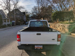 Rear view of a well-maintained 2011 Ford Ranger parked on a street, with trees and houses in the background.
