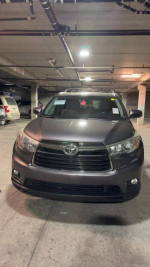 Front view of a 2015 Toyota Highlander XLE FWD, Alumina Jade Metallic, in a parking garage.