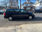 2012 Dodge Grand Caravan parked on the street, showcasing its clean design and spacious interior.