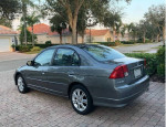 2004 Honda Civic LX in excellent condition, gray color, parked in a residential area with trees.