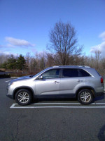 2015 Kia Sorento EX in silver parked, showcasing its sleek design and new upgrades, ideal for families and travel.