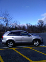 2015 Kia Sorento EX FWD parked in a lot, showcasing its new tires and sleek exterior.