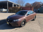2015 Ford Taurus Police Package car parked, showcasing its brown exterior and AWD features.