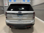 Rear view of a 2013 Ford Explorer Sport AWD showing wear and rust on tailgate in a garage setting.