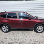 Side view of a red Honda CR-V EX with sunroof and backup camera, showcasing its sleek design.