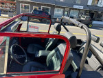 Interior view of a 1976 Jeep CJ7 with black leather seats and classic dashboard, ready for off-road adventures.