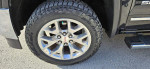 Close-up of the polished aluminum wheel and tire on a 2018 GMC Sierra 1500 SLT 4x4, showcasing excellent condition.
