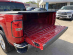 Open bed of a 2014 GMC Sierra 1500 SLE in Fire Red, showcasing its spacious interior and design features.