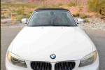 Front view of a 2013 BMW 1 Series 128i convertible with a white exterior and a black soft top.