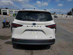 Rear view of a 2021 Toyota Highlander Hybrid Platinum, showcasing its design in a parking lot.