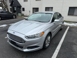 2013 Ford Fusion SE in silver parked, showcasing a clean body and modern design, ideal for daily commuting.