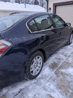 2012 Nissan Altima 2.5 FWD parked on snow, featuring clean exterior and well-maintained condition.