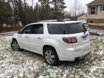 2016 GMC Acadia Denali SUV in white, parked in snow, showcasing its features and well-maintained exterior.