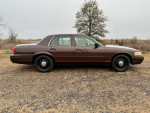 2008 Ford Crown Victoria P71 Police Interceptor with 101,000 miles, parked outdoors on a gravel road.