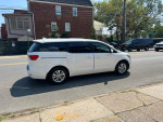 2016 Kia Sedona L van parked on the street, featuring spacious seating for seven passengers