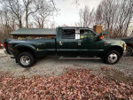 2010 Ford F350 Dually Super Duty Diesel truck parked on gravel with fallen leaves.