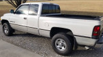 1996 Dodge Ram 1500 4x4 extended cab with off-road tires, parked on gravel