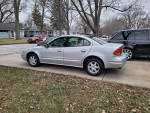 2003 Oldsmobile Alero GL in Brilliant Silver Metallic parked on a driveway, showcasing its sleek design and alloy wheels.