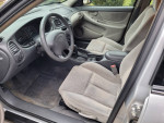 Interior view of a 2003 Oldsmobile Alero GL with grey cloth seats and dashboard.