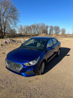 2019 Hyundai Accent SE blue sedan parked on gravel with clear sky, features front wheel drive and backup camera.