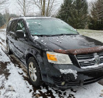 2008 Dodge Caravan parked in snow, features a cracked windshield and some rust, located in Alto, MI.