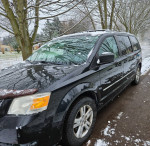 2008 Dodge Caravan minivan parked in snow, featuring new battery and tires, some rust visible on the body.