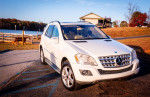 2010 Mercedes-Benz ML-350 in white parked near a lake, showcasing its stylish design and features.