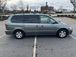 2001 Honda Odyssey EX FWD minivan parked, showing clean exterior and good tire condition, with some cosmetic wear.