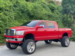 2006 Dodge Ram 2500 Mega Cab in red with new tires and custom wheels, located outdoors