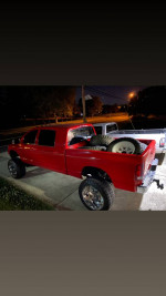 2006 Dodge Ram 2500 mega cab diesel with spare tires at night, showcasing a lifted truck design.