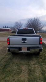Rear view of a 2015 Chevrolet Silverado 1500 LT 4WD, showcasing the bed and towing features.