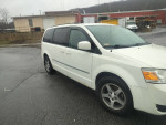White 2010 Dodge Grand Caravan parked with a clean exterior, featuring three-row seating and stow-and-go functionality.