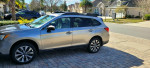 2017 Subaru Outback 2.5i AWD parked in a residential area with vibrant landscaping