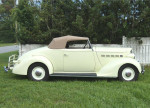 Classic 1936 Packard 120B convertible coupe parked in lush green grass