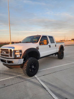 2009 Ford F250 Superduty Lariat Diesel truck with custom wheels in a parking lot
